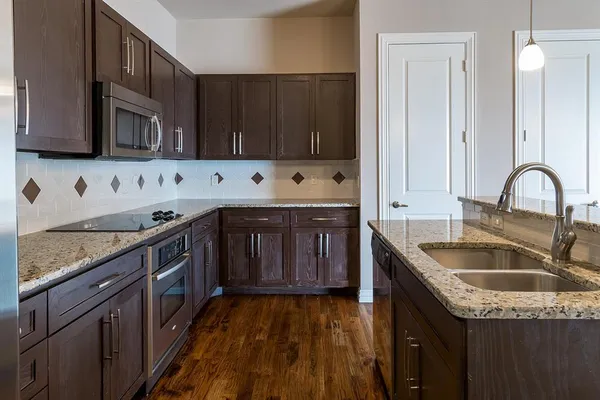 a kitchen with granite countertop a sink and a stove