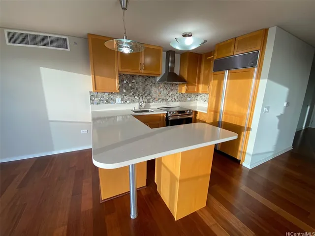 a kitchen with a wooden floor and a refrigerator