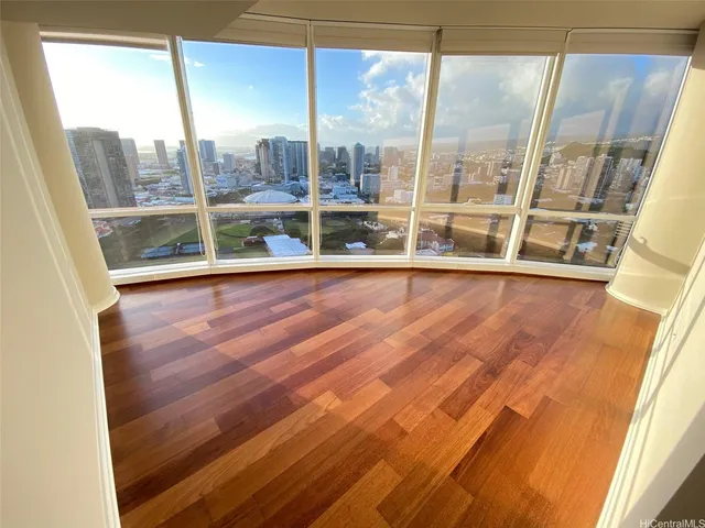 a view of empty room with wooden floor and fan