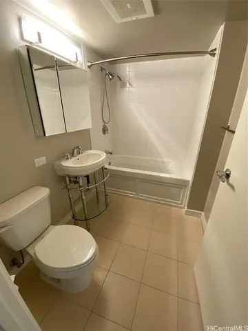 a white toilet sitting next to a bath tub