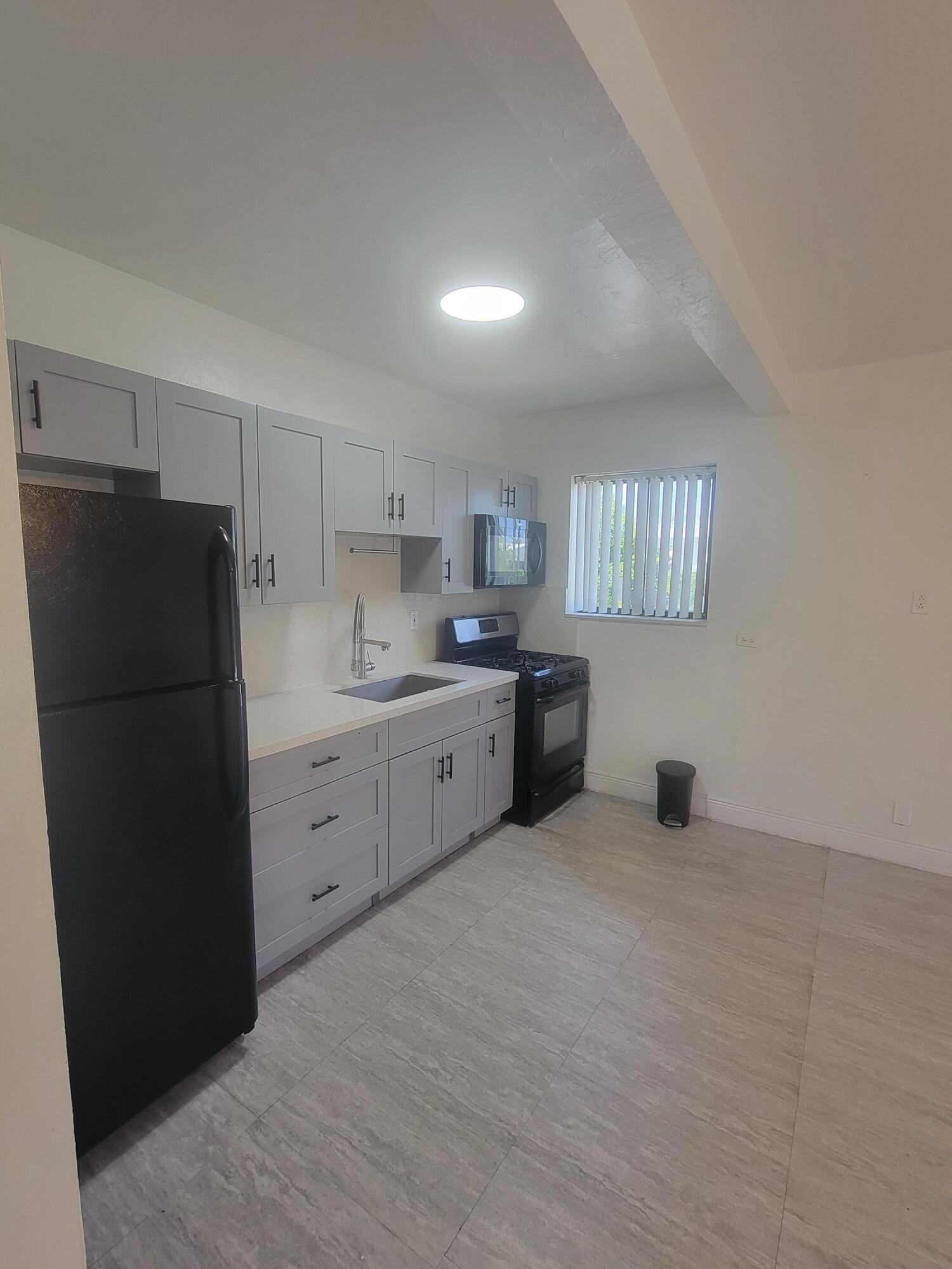 1845 Pembroke Road, Unit 212 Hollywood, FL 33020 - Photo 5 of 10 a kitchen with a refrigerator sink and cabinets