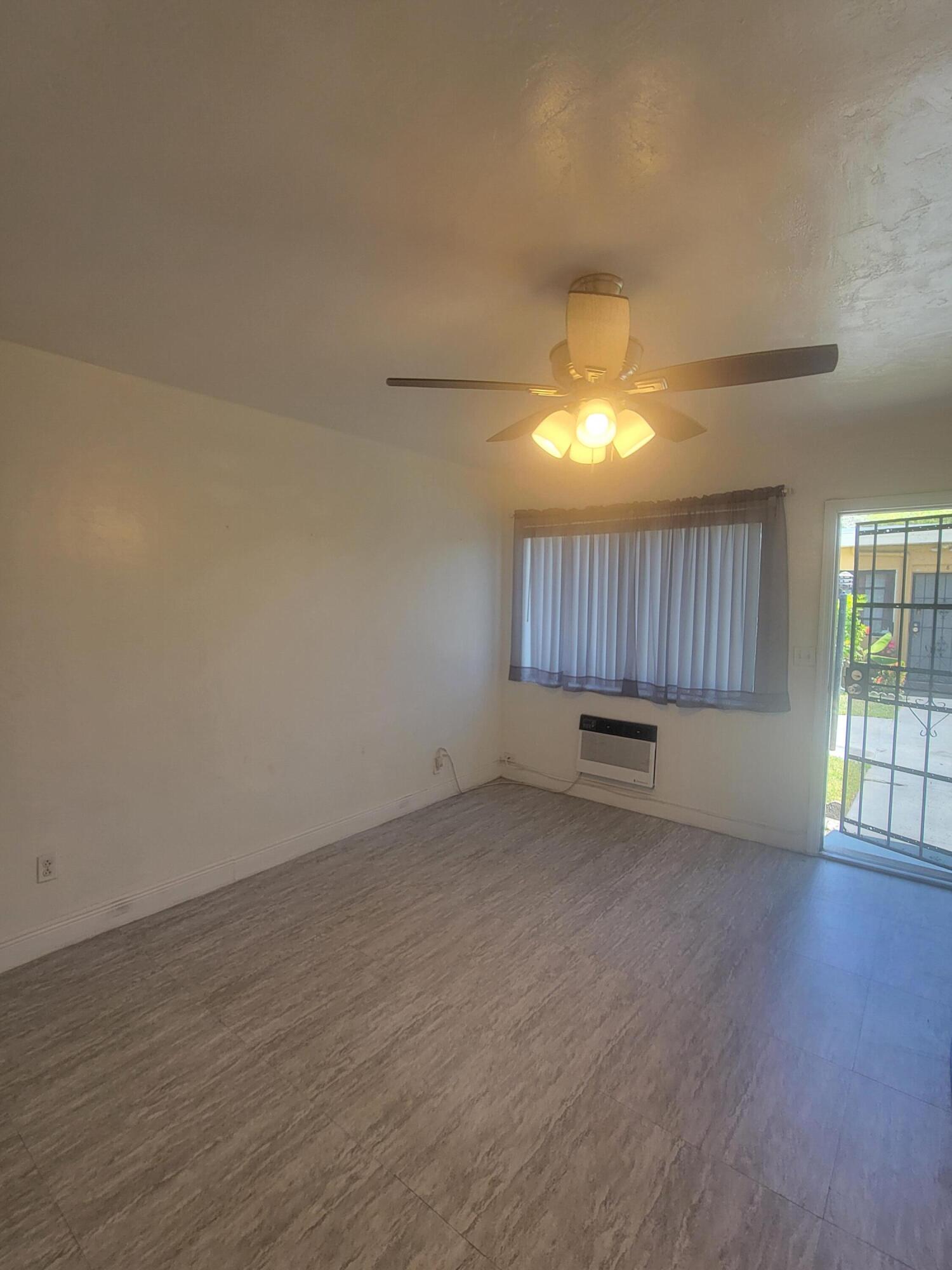 1845 Pembroke Road, Unit 212 Hollywood, FL 33020 - Photo 7 of 10 an empty room with wooden floor and window