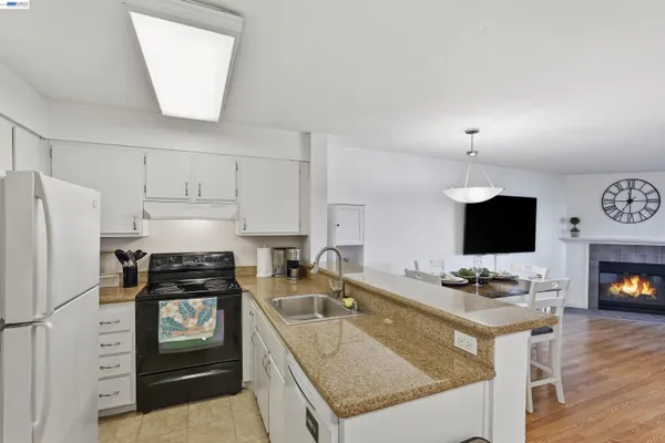 a kitchen with granite countertop a refrigerator stove and sink