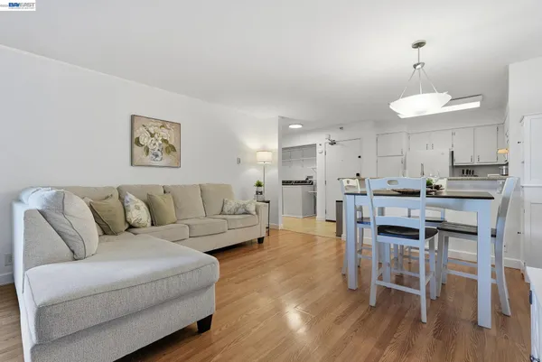 a living room with stainless steel appliances kitchen island granite countertop furniture and wooden floor