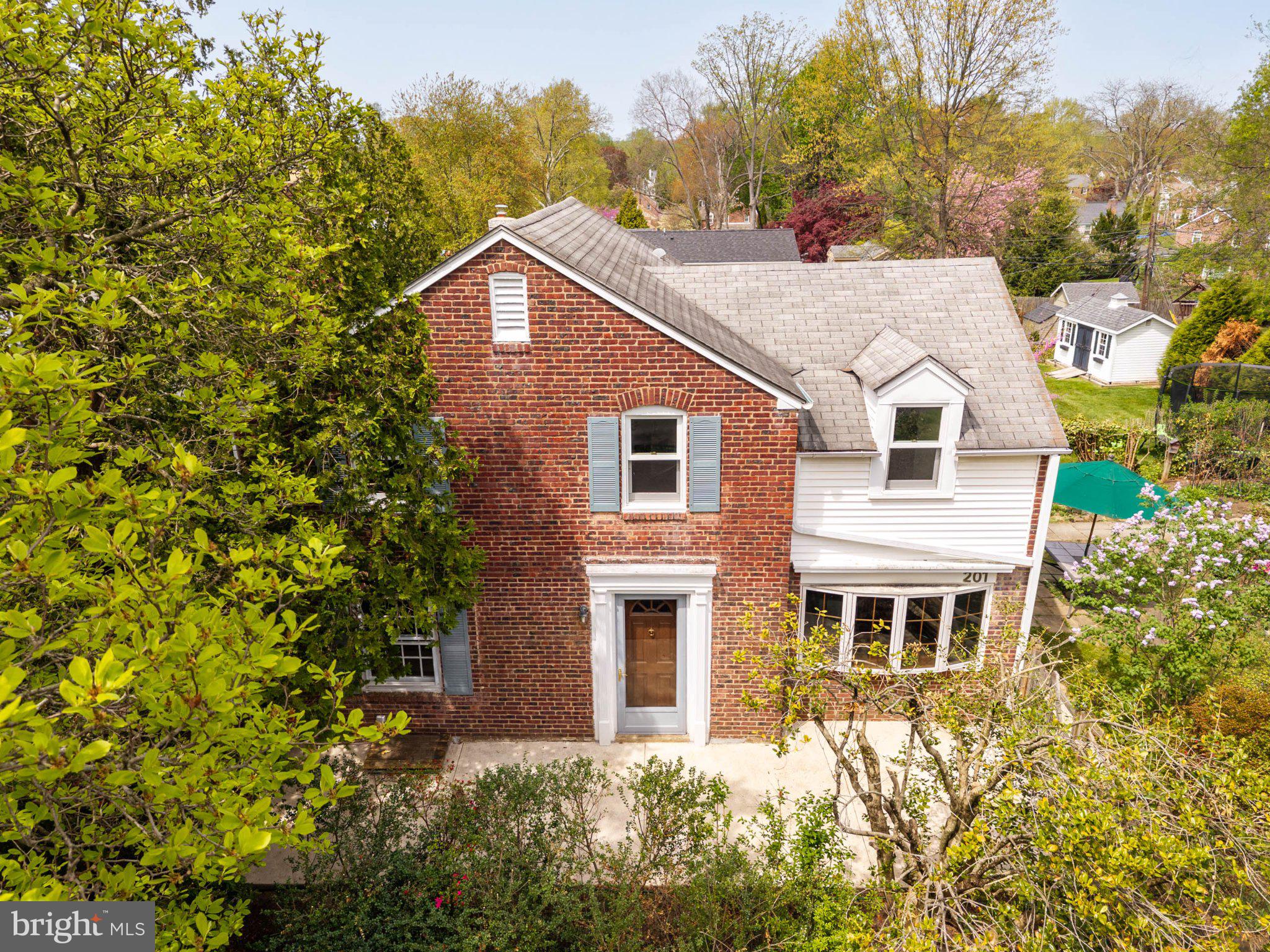 Charming brick home with lush greenery.