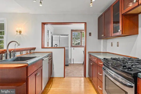 a kitchen with stainless steel appliances granite countertop a sink stove and cabinets