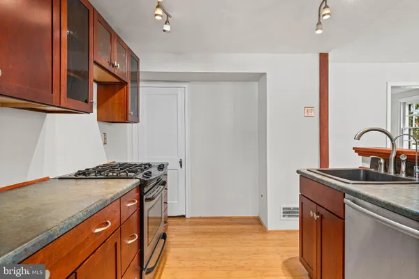 a kitchen with stainless steel appliances granite countertop a sink stove and cabinets