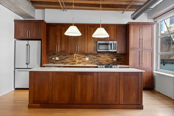 a kitchen with stainless steel appliances wooden cabinets and a counter top space