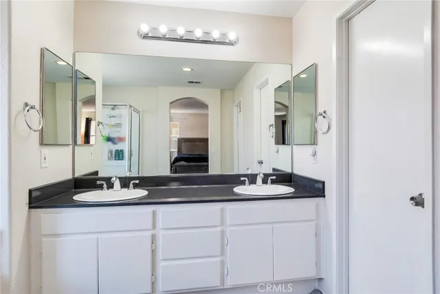 a bathroom with double vanity sinks and a mirror