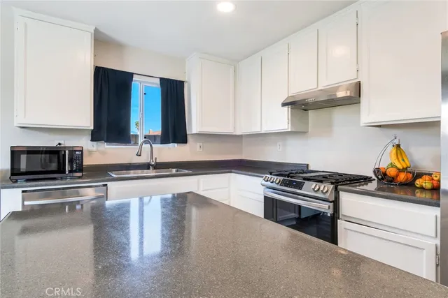 a kitchen with stainless steel appliances granite countertop a stove and a sink