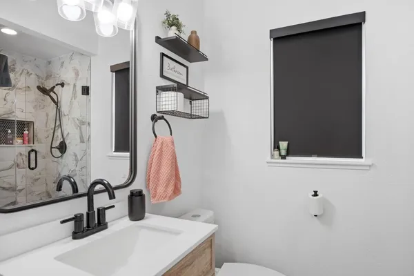 a bathroom with a sink and mirror with toilet