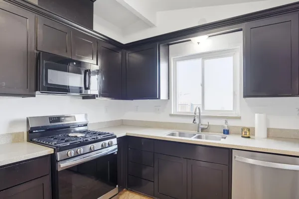 a kitchen with stainless steel appliances a sink stove and microwave