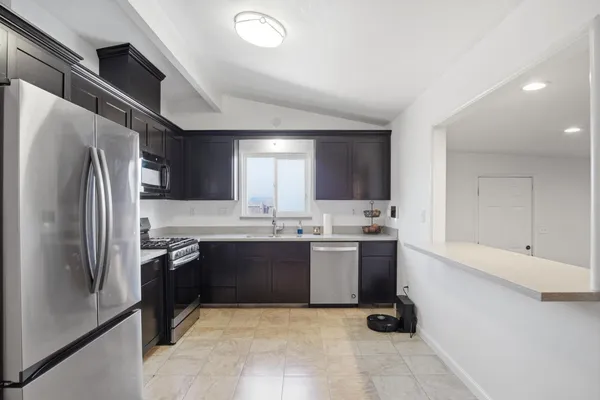 a kitchen with stainless steel appliances granite countertop a refrigerator and a sink