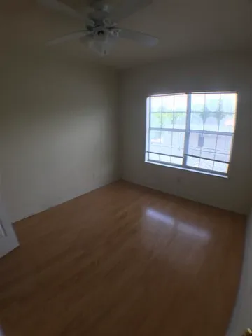 a view of an empty room with a chandelier fan