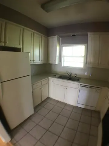 a kitchen with a sink a refrigerator and cabinets