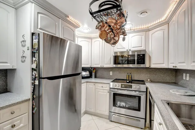 a kitchen with stainless steel appliances granite countertop a refrigerator sink and cabinets