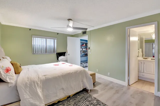 a bedroom with a large bed and a chandelier