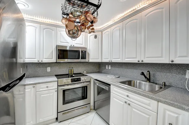 a kitchen with white cabinets and stainless steel appliances