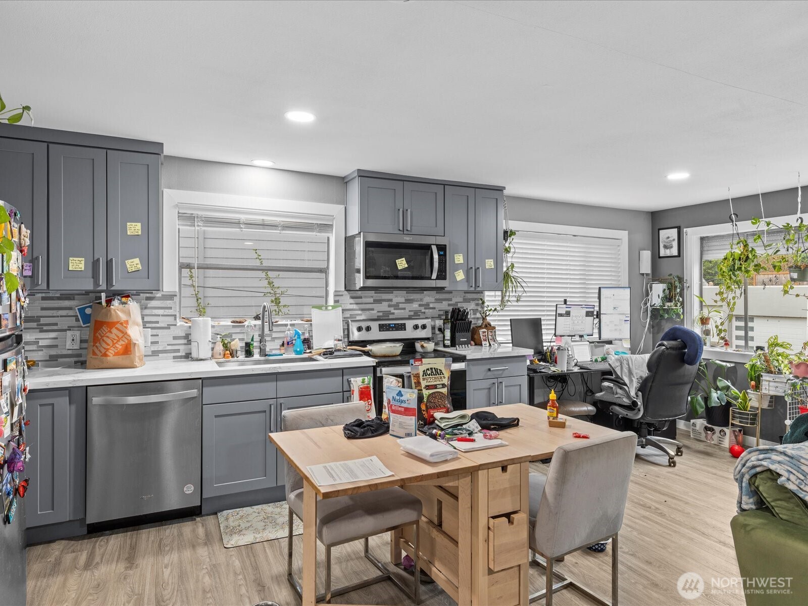 7138 47th Avenue Southwest Seattle, WA 98136 - Photo 7 of 20 a kitchen with a table chairs microwave and cabinets
