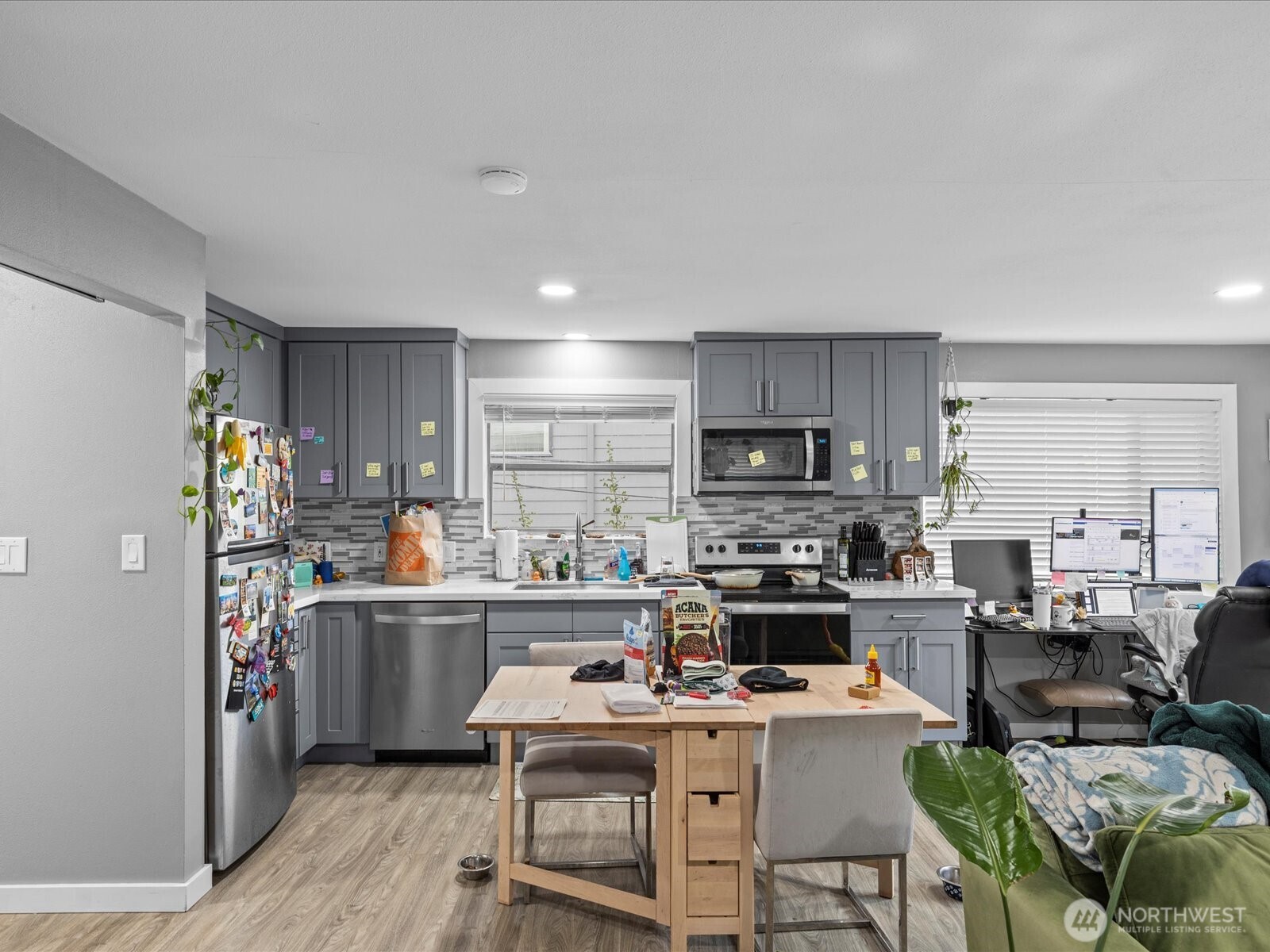 7138 47th Avenue Southwest Seattle, WA 98136 - Photo 8 of 20 a kitchen with stainless steel appliances a stove a sink a refrigerator cabinets and dining table