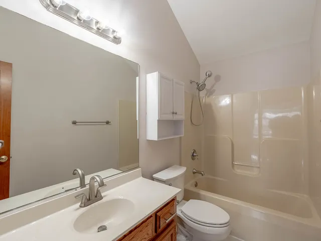 a bathroom with a sink toilet vanity and shower