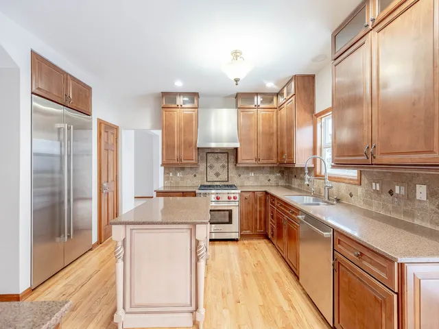 a kitchen with stainless steel appliances granite countertop a sink stove and refrigerator