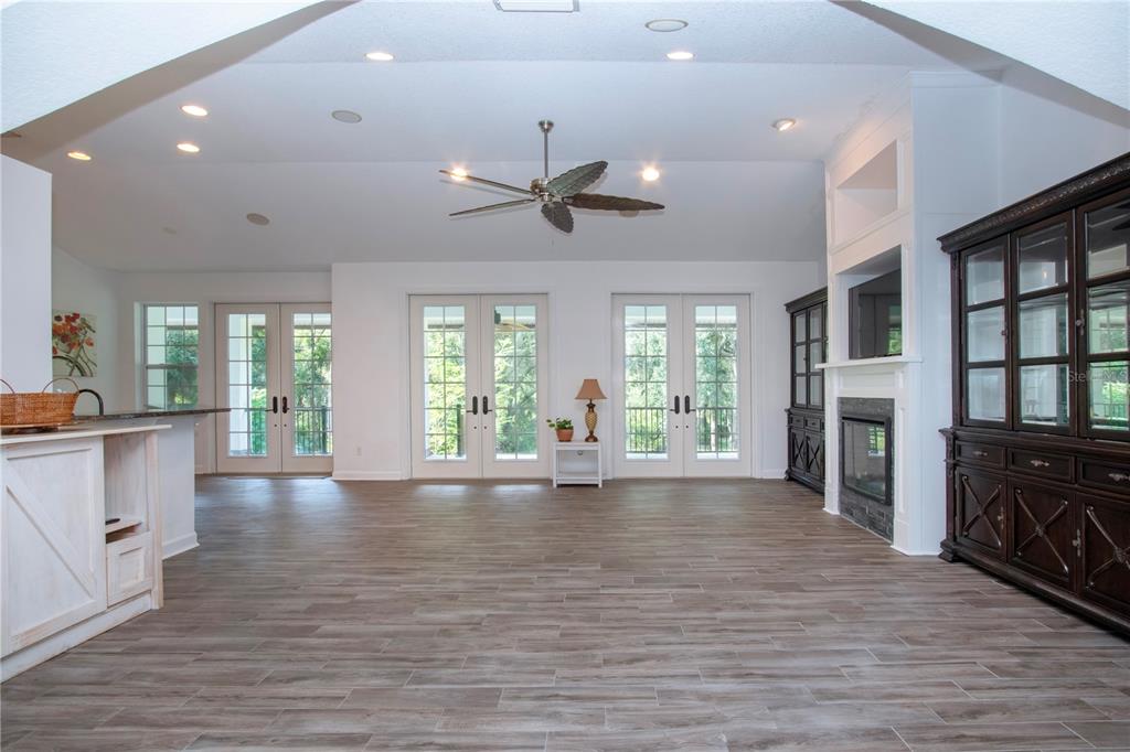1422 Lightfoot Road Wimauma, FL 33598 - Photo 22 of 98 a view of an empty room with wooden floor and a kitchen