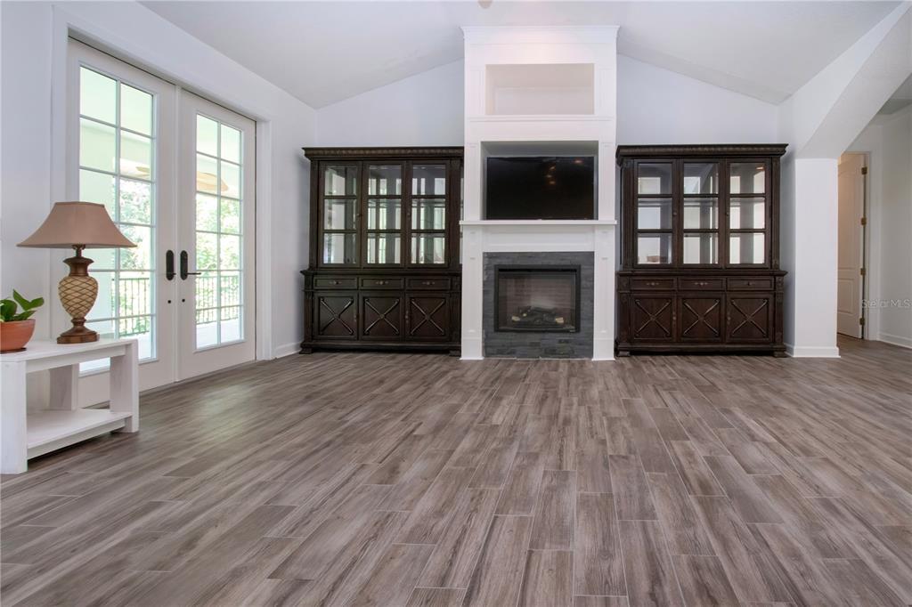 1422 Lightfoot Road Wimauma, FL 33598 - Photo 26 of 98 a living room with a fireplace and a wooden floor