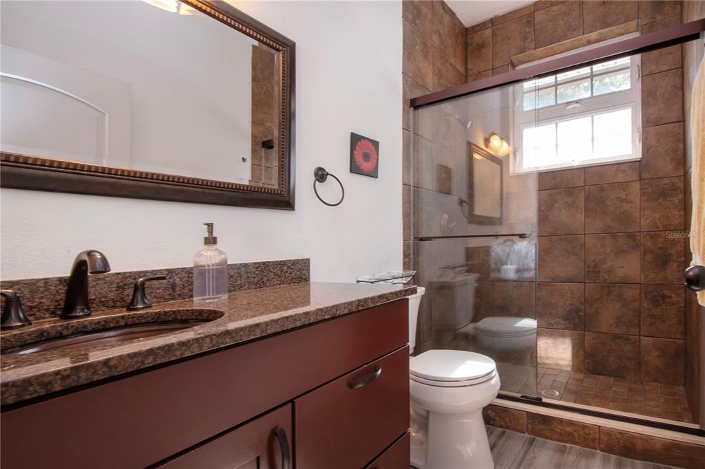 1422 Lightfoot Road Wimauma, FL 33598 - Photo 45 of 98 a bathroom with a granite countertop sink mirror vanity and toilet