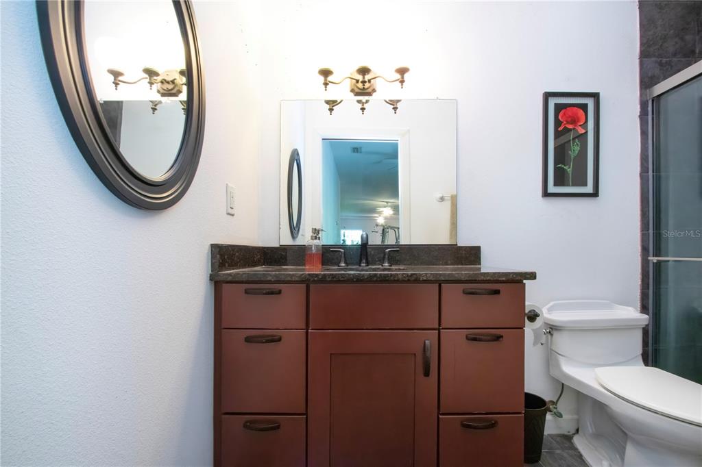 1422 Lightfoot Road Wimauma, FL 33598 - Photo 60 of 98 a bathroom with a toilet a sink and a mirror