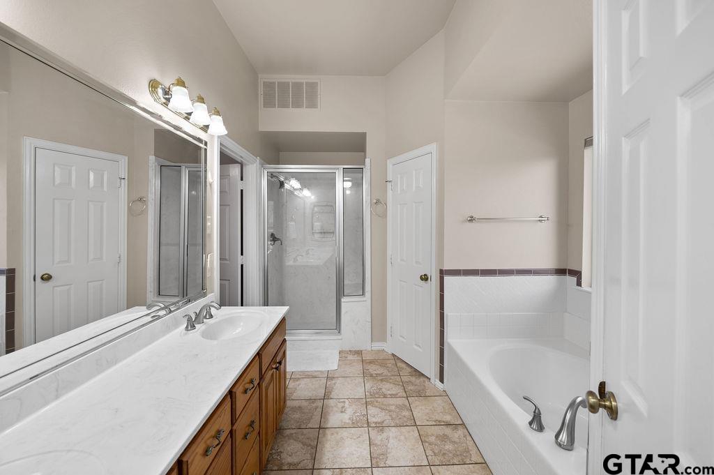 863 County Road 2950 Alba, TX 75410 - Photo 16 of 33 a bathroom with a granite countertop sink a large mirror and a bathtub