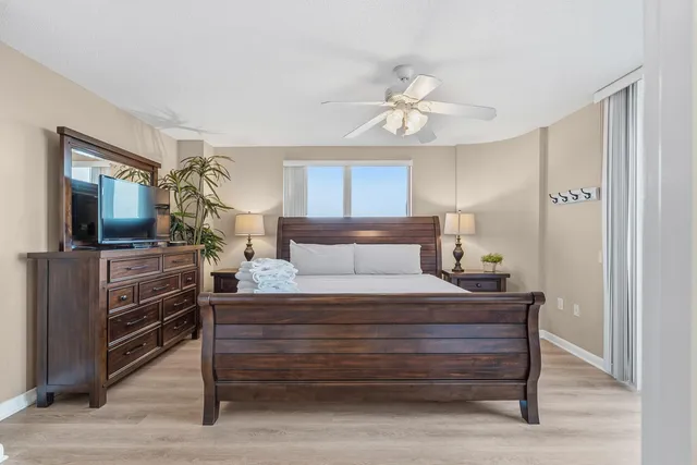 a bedroom with a large bed and a chandelier