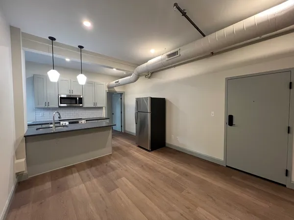 a large kitchen with granite countertop a large counter top stainless steel appliances and cabinets