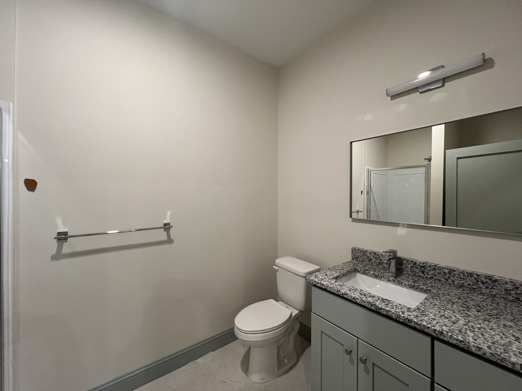 160 Seabury Street, Unit 7 Fall River, MA 02720 - Photo 4 of 11 a bathroom with a granite countertop toilet and a sink