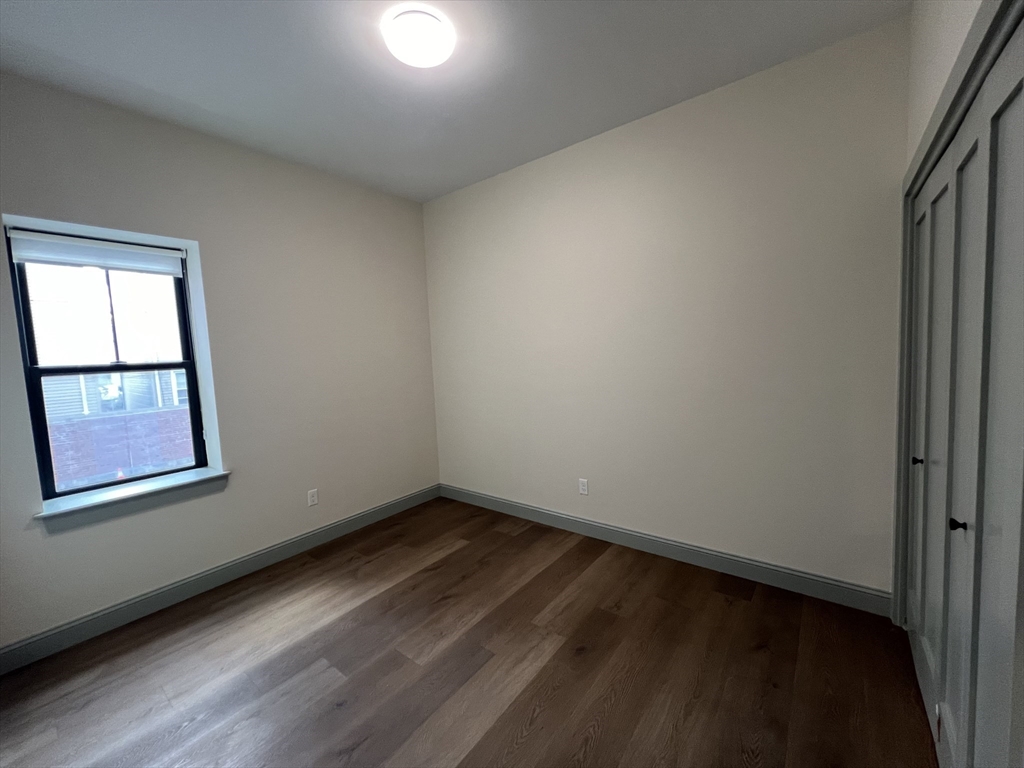 160 Seabury Street, Unit 7 Fall River, MA 02720 - Photo 8 of 11 an empty room with wooden floor and windows