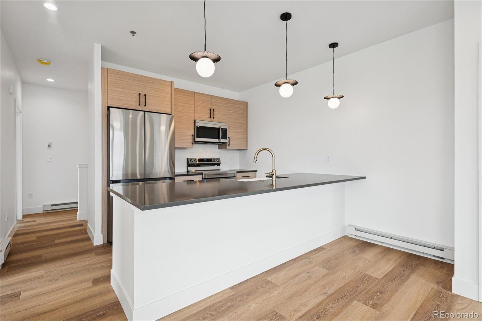 360 Sterling Way, Unit 2 Fraser, CO 80442 - Photo 11 of 30 a kitchen with kitchen island a sink stainless steel appliances and wooden floor