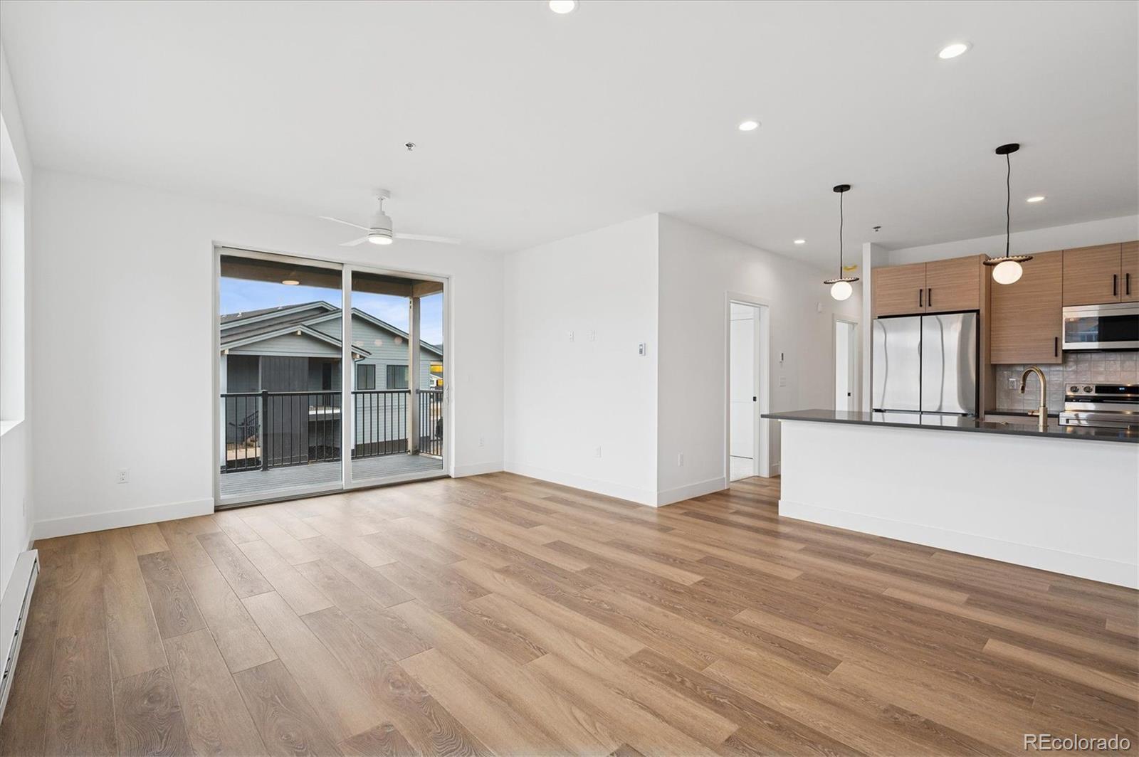 360 Sterling Way, Unit 2 Fraser, CO 80442 - Photo 15 of 30 a view of an empty room with wooden floor and a kitchen