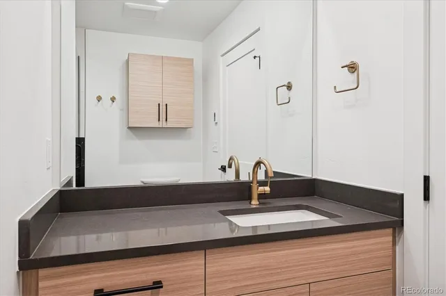 a close view of a sink a counter and a mirror in a bathroom