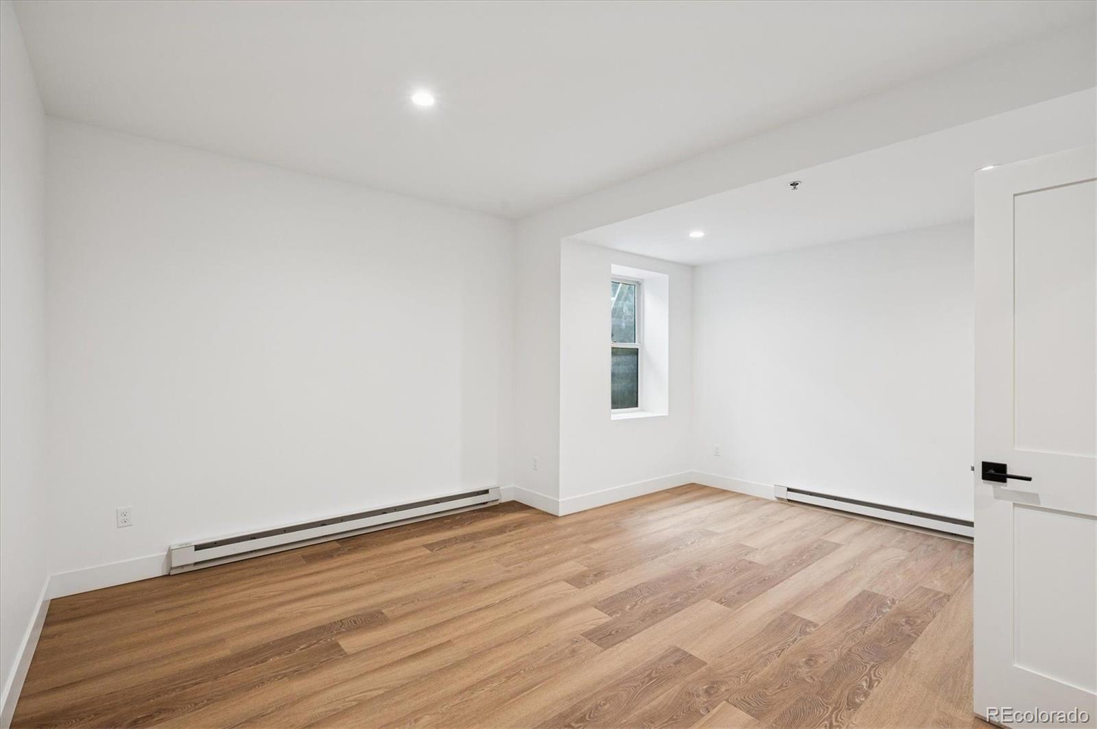360 Sterling Way, Unit 2 Fraser, CO 80442 - Photo 23 of 30 a view of an empty room with wooden floor and a window