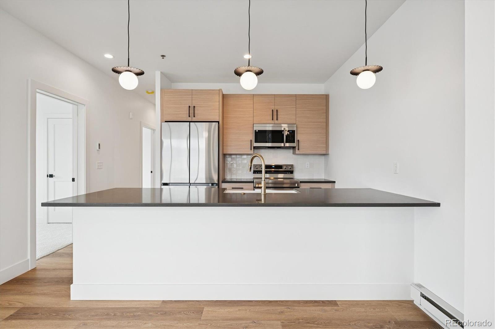 360 Sterling Way, Unit 2 Fraser, CO 80442 - Photo 10 of 30 a large room with kitchen island a stove a sink and a chandelier