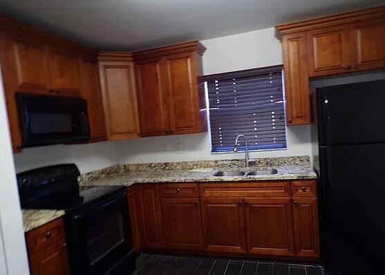 3391 Avenue South Riviera Beach, FL 33404 - Photo 7 of 16 a kitchen with granite countertop stainless steel appliances and wooden cabinets