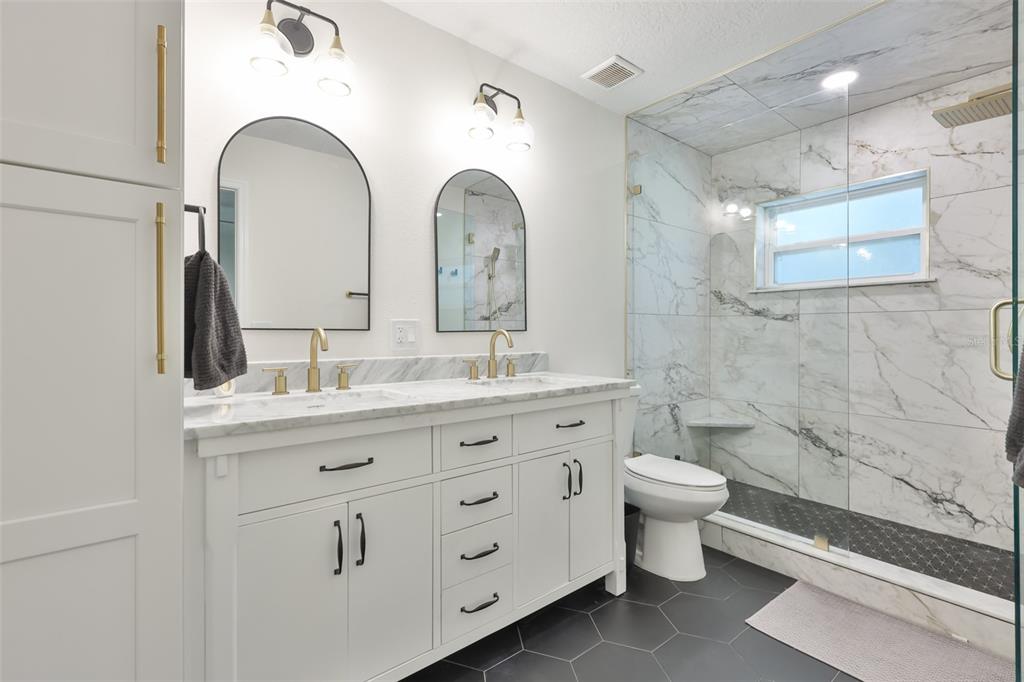 1578 Indian Bay Road Spring Hill, FL 34607 - Photo 28 of 51 a bathroom with a double vanity sink a toilet and a mirror
