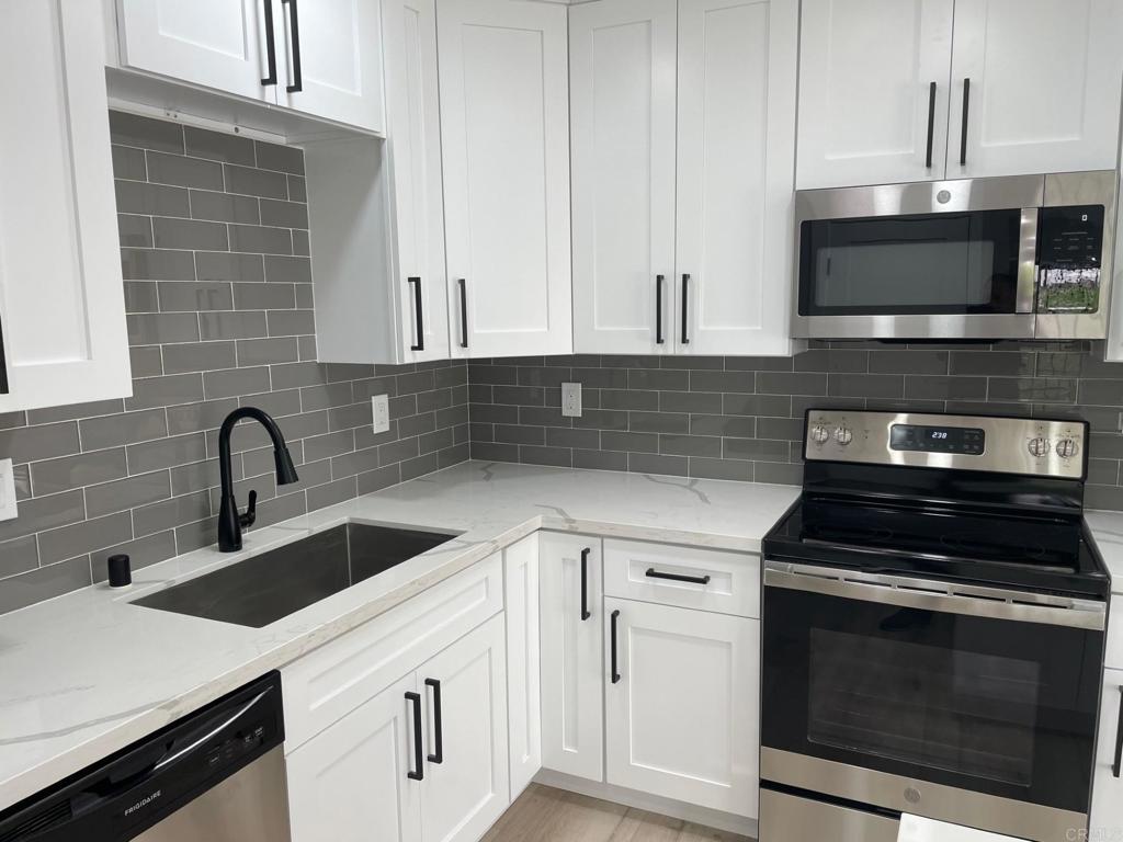 a kitchen with stainless steel appliances granite countertop a sink stove and microwave