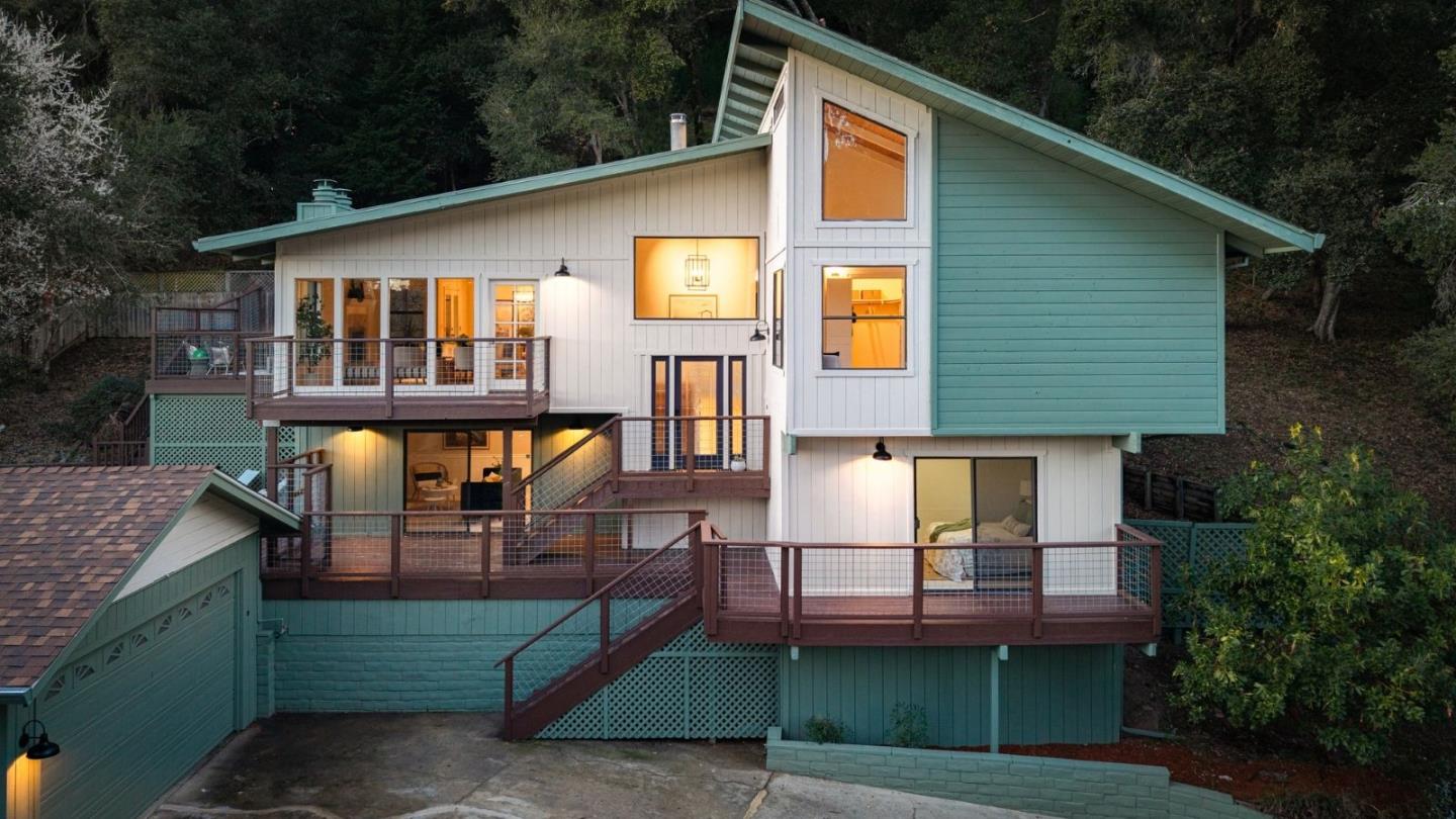 a view of a house with wooden deck and furniture