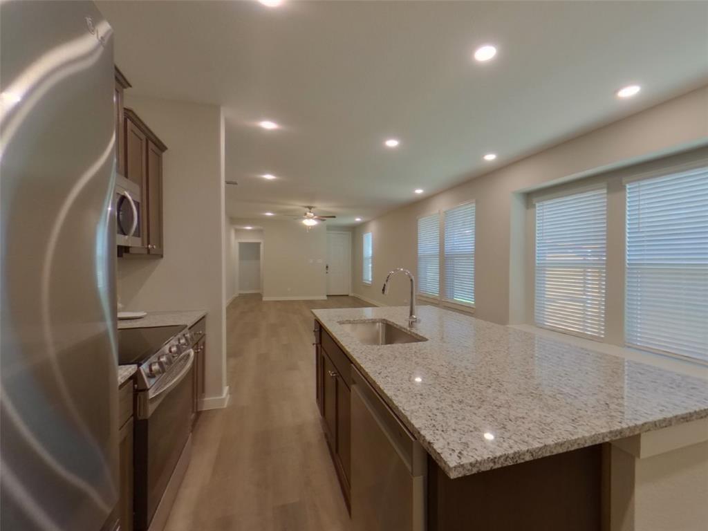 2545 Waddill Rivers Way McKinney, TX 75071 - Photo 3 of 9 a kitchen with stainless steel appliances granite countertop a sink and a refrigerator