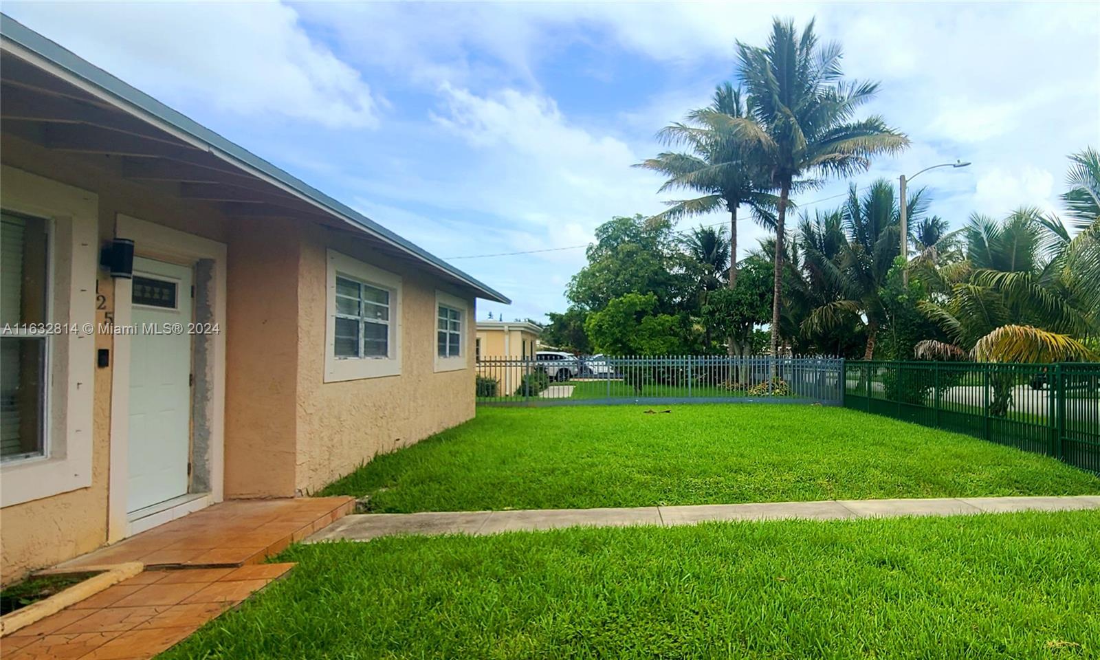 125 Northeast 193rd Street Miami, FL 33179 - Photo 1 of 20 a front view of house with yard and green space