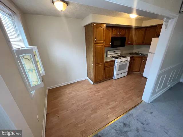 a kitchen with granite countertop a refrigerator and a stove top oven