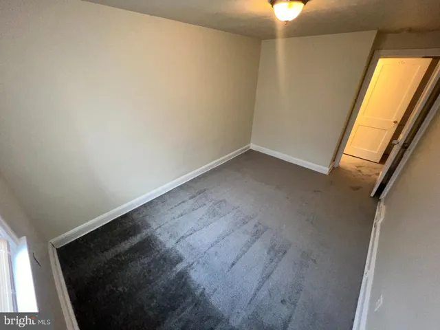 en empty room with wooden floor and window