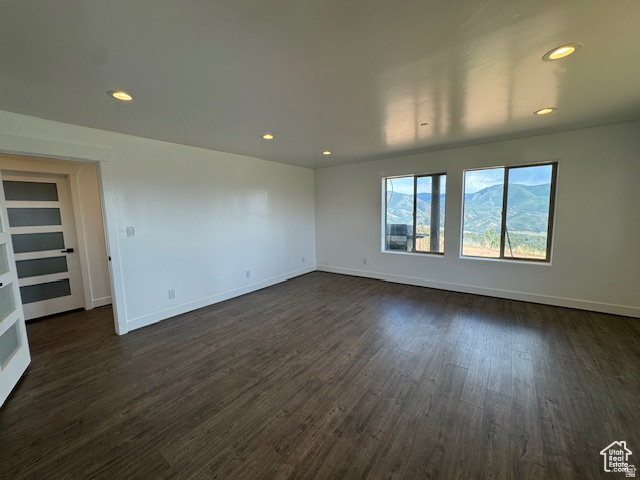 6909 East Spring Drive, Unit 19 Springville, UT 84663 - Photo 58 of 118 Spacious room featuring wood-finish flooring, recessed lighting, and two large windows showcasing a mountain backdrop