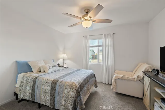a bedroom with a bed and a ceiling fan
